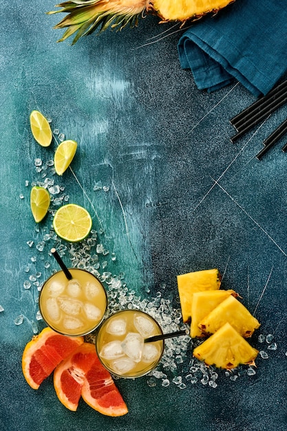 Suco fresco de abacaxi com gelo e fatias maduras de frutas tropicais de toranja, laranja, limão,