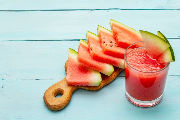 Suco fresco de melancia, batido, coquetel. Sobremesa doce de verão, fatias na tábua de madeira