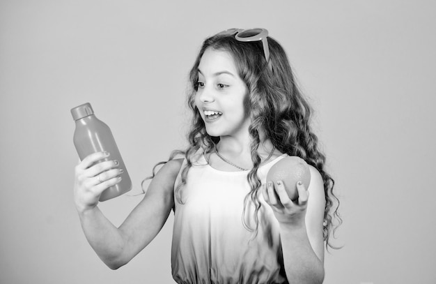 Suco vitamínico refrescante Cuidados com a saúde Dieta vitamínica de verão Fonte natural de vitamina menina feliz bebe suco de laranja fresco férias de verão menina em óculos de moda apaixonada por comida saudável