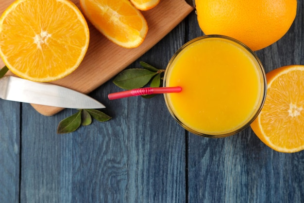 Sucos cítricos. Suco de laranja com laranjas frescas em uma mesa de madeira azul. vista de cima. espaço para texto