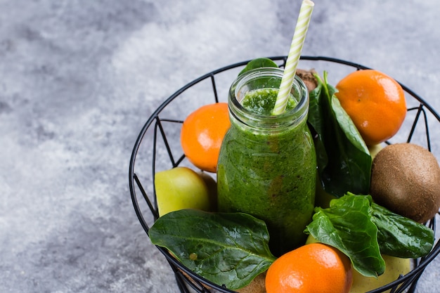 Sucos verdes ou smoothies com kiwi, espinafre, maçã verde, amêndoa cítrica e porca na cesta de metal