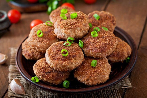 Sucosas y deliciosas chuletas de carne en una mesa de madera en un estilo rústico