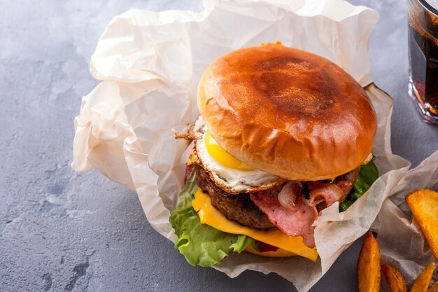 Suculento hambúrguer de carne com bacon frito, ovo e queijo