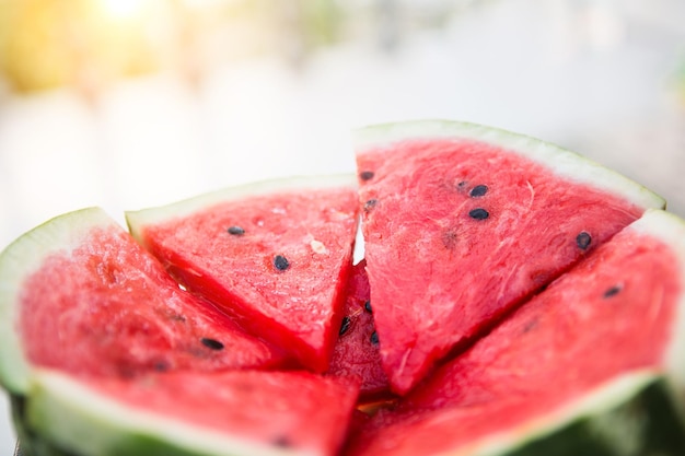 Suculentos pedaços vermelhos brilhantes de melancia fatiada em um fundo de mesa preta