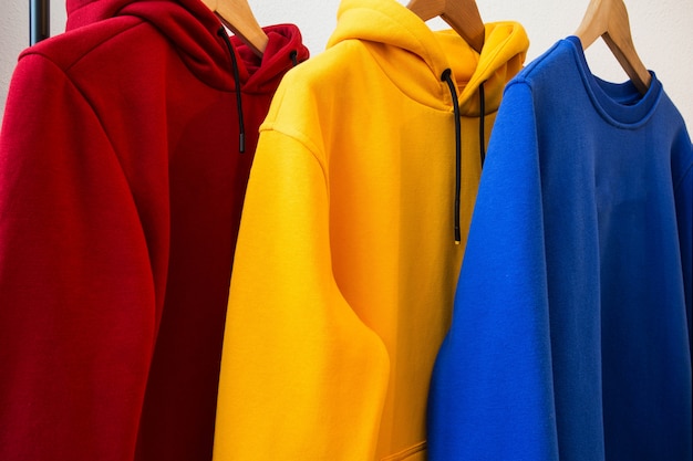 Foto sudaderas con capucha coloridas en diseño moderno de primer plano de perchas