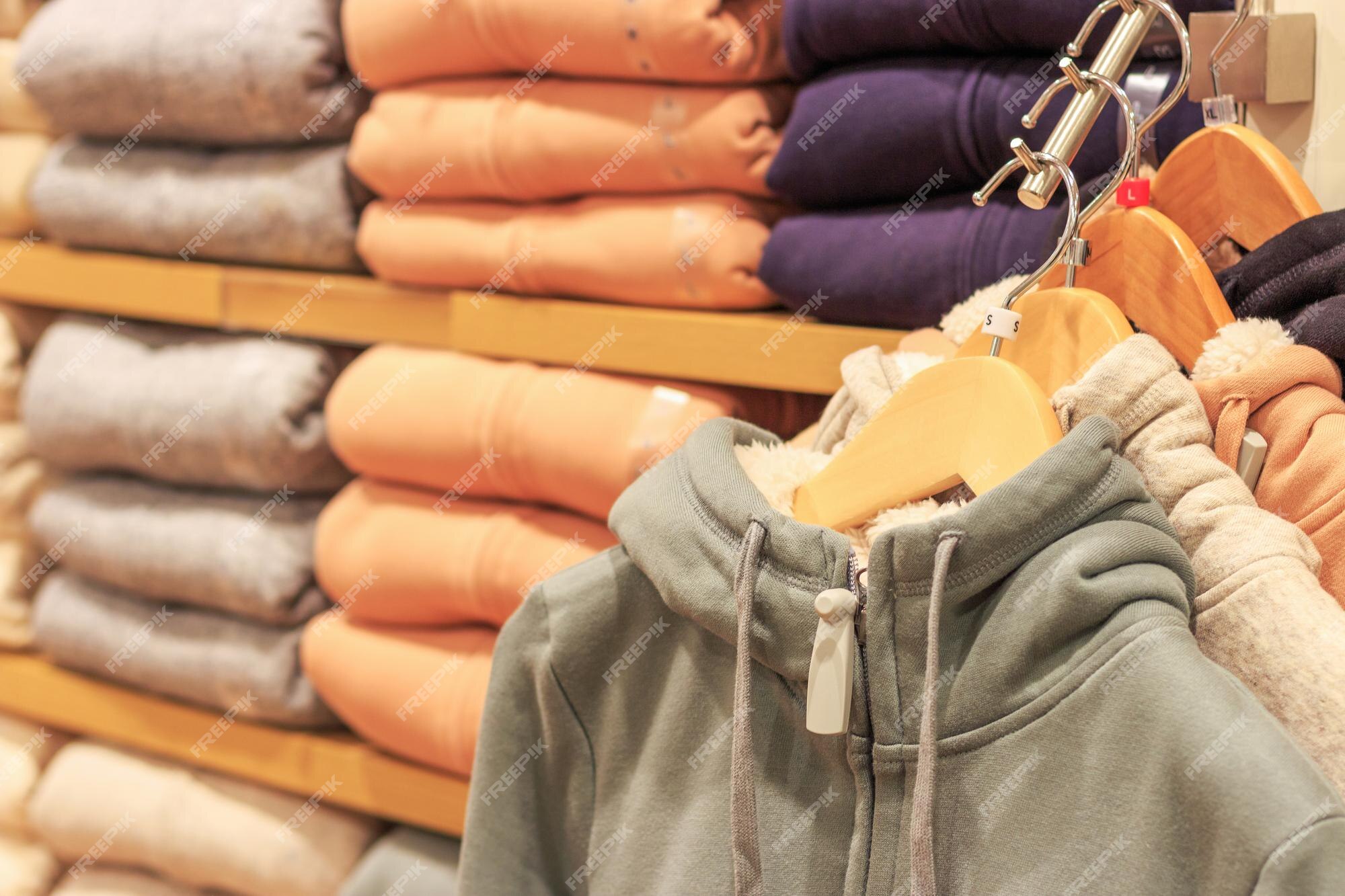 Sudaderas con capucha multicolores en perchas en una tienda de deportes cerca. | Foto Premium