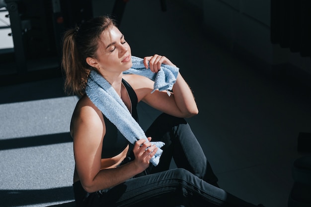 Sudando después del entrenamiento. Hermosa mujer rubia en el gimnasio en su fin de semana