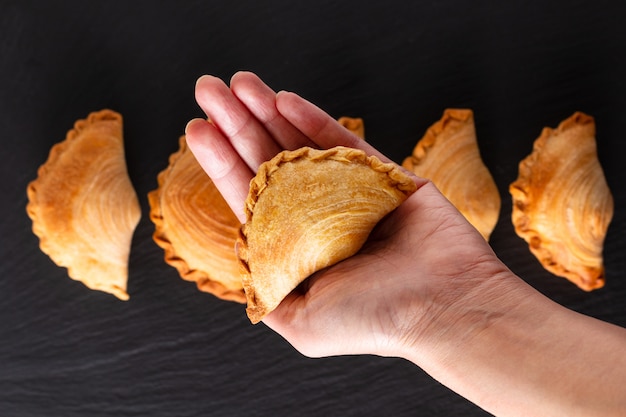 Sudeste da ásia origem comida conceito caseiro frango curry puffs em fundo de pedra ardósia preto com espaço de cópia