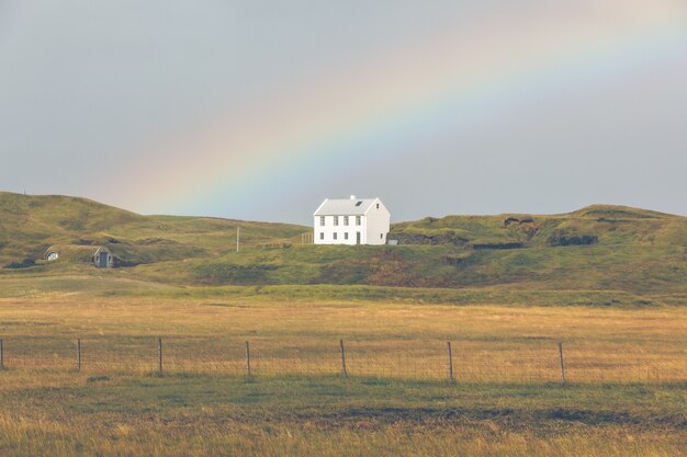 Südisländische Landschaft mit Haus und Regenbogen