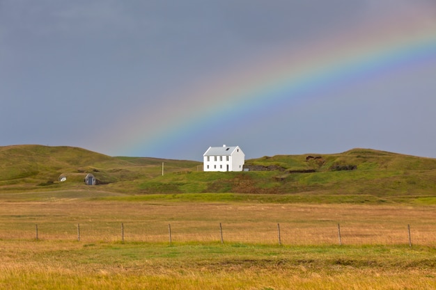 Südisländische Landschaft mit Haus und Regenbogen