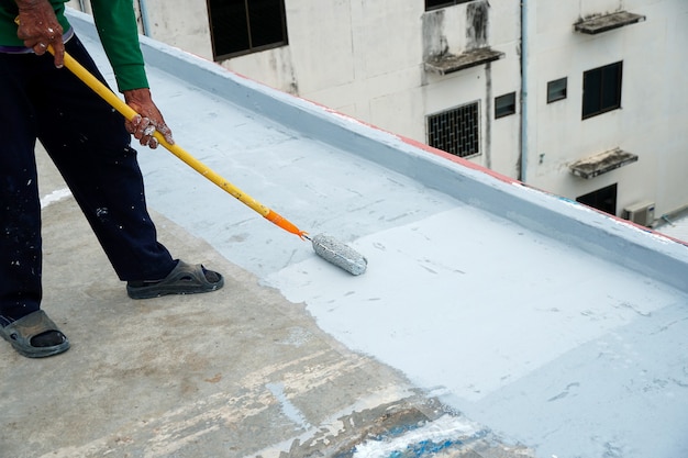 Suelo gris pintado a mano con rodillos de pintura para una red de refuerzo impermeable