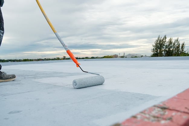 Suelo gris pintado a mano con rodillos de pintura para una red de refuerzo impermeable