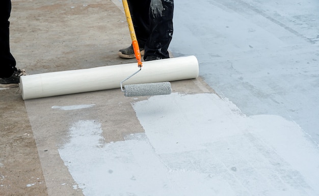 Suelo gris pintado a mano con rodillos de pintura para red de refuerzo impermeable