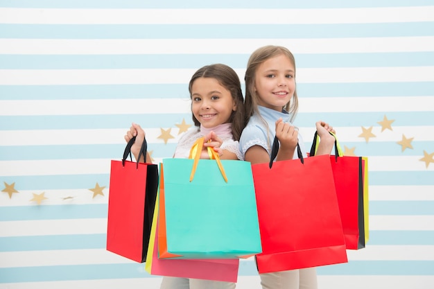 Sueña con todas las chicas comprando junto con su mejor amiga Las mejores amigas de los niños de las niñas sostienen un montón de bolsas de compras Venta y descuento de temporada Posible comprar felicidad Hermanas amigas felices con bolsas