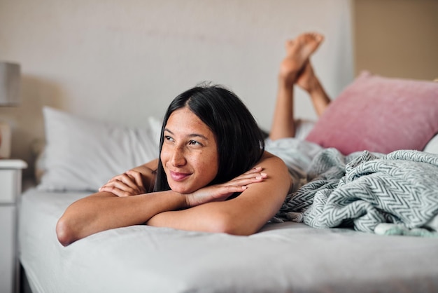 Los sueños despiertos nos dan algo que esperar. Foto de una mujer joven que disfruta de un momento relajante en la cama de su casa.