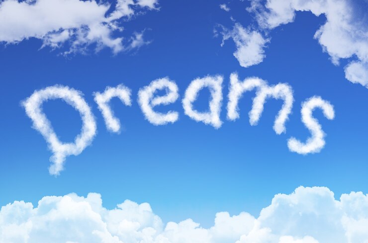 Foto sueños de palabra de las nubes contra el cielo azul.