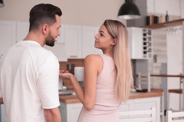 Sueños de una pareja joven de pie en su cocina