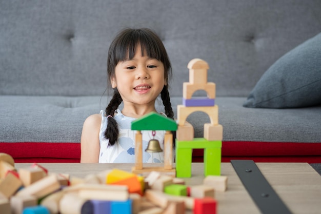 Süße asiatische kleine Mädchen spielen mit bunten Spielzeugblöcken Kinder spielen mit Lernspielzeug im Kindergarten oder in der Kindertagesstätte Das kreative Spielen des Kinderentwicklungskonzepts Kleinkindkind im Kindergarten