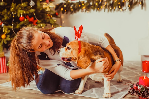 Süße Besitzerin mit Hund auf der Weihnachtsfeier. Frohes neues Jahr.