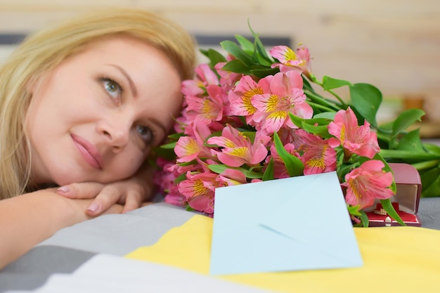 süße blonde Frau mit schönem Strauß frischer Blumenstrauß für Mädchenblumenlieferung