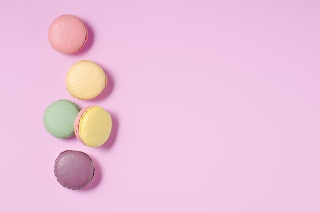 Süße bunte Macarons auf rosa Hintergrund Leckere bunte Macarons