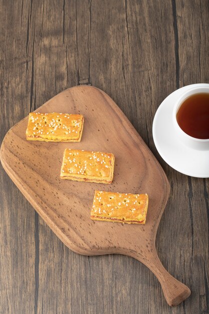 Süße Cracker mit Samen und einer weißen Tasse heißen Tees.