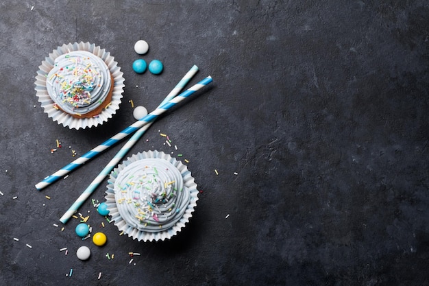 Süße Cupcakes mit bunter Dekoration und Süßigkeiten. Top-Ansicht mit Platz für Ihre Grüße
