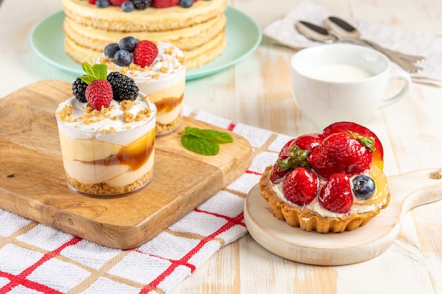 Süße Desserts mit frischen Beeren auf Holzhintergrund.