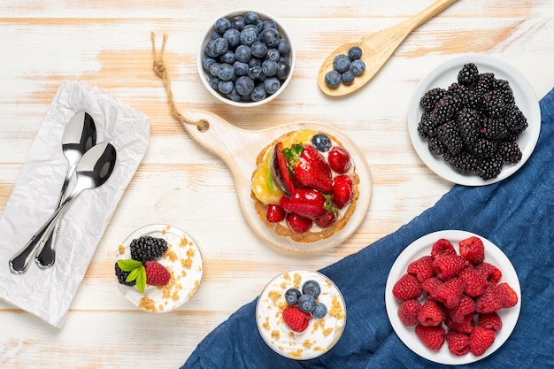 Süße Desserts mit frischen Beeren auf Holzoberfläche