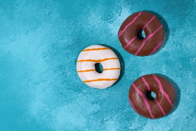 Süße Donuts auf blauem Grund