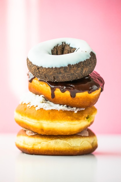 Süße Donuts in verschiedenen leuchtenden Farben liegen in einem großen Haufen auf einem farbigen Hintergrund