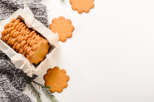 Süße dünne Ingwerplätzchen in einer Geschenkbox auf weißem Hintergrund auf einem Plaid.