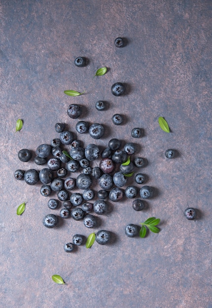 Süße frische Blaubeeren auf dunklem Betonhintergrund. Draufsicht und Platzbild kopieren