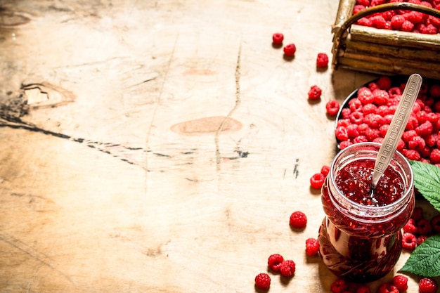 Süße Himbeermarmelade im Glas mit Löffel.