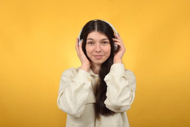 süße junge Frau, die Musik über Kopfhörer genießt