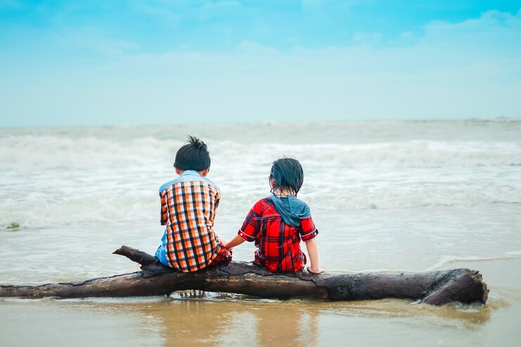 süße Jungs spielen am Strand