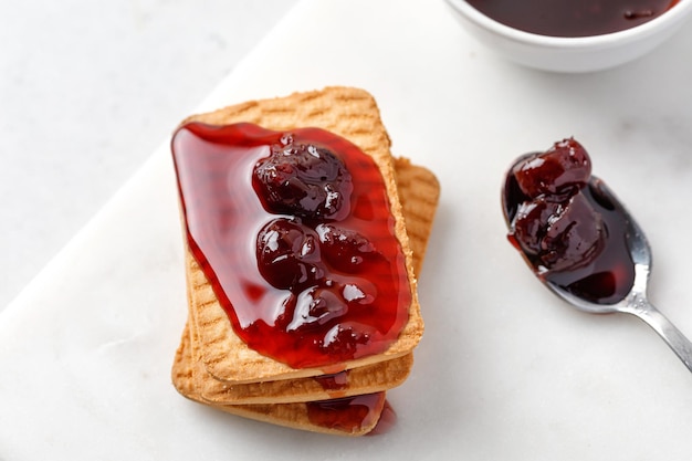 Süße Kekse mit Kirschmarmelade und Löffel Confiture