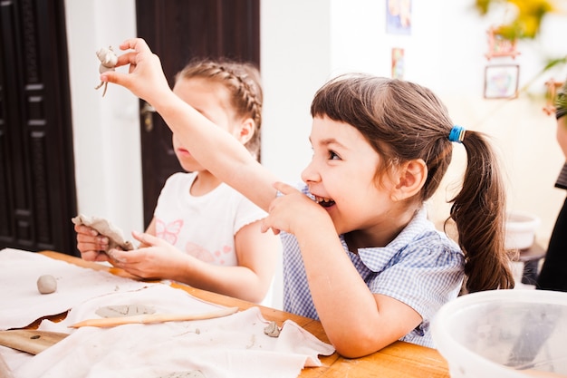 Süße Kinder formen mit natürlichem Ton. Natürlicher Tast- und Spielunterricht