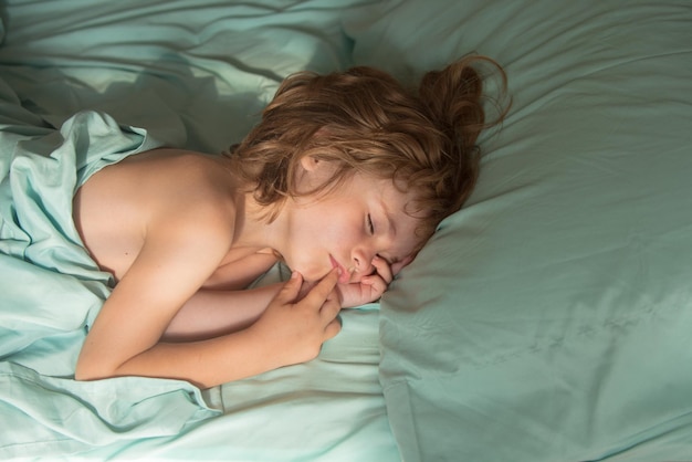 Süße Kinder schlafen im Bett und liegen auf weichen Kissen.