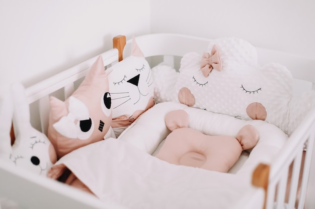 süße kinderzimmerdekoration stylische babyzimmereinrichtung mit bequemer krippe und lustigen rosa dekorativen kissen