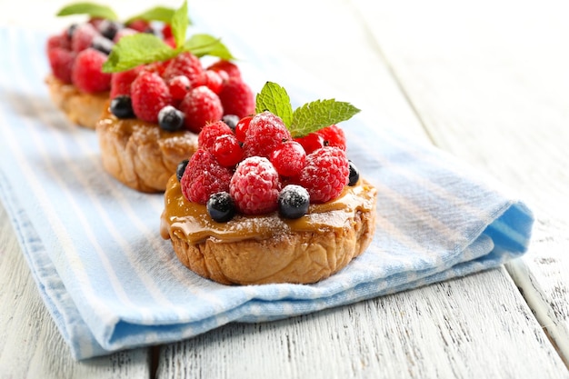 Süße Kuchen mit Beeren auf dem Tisch in der Nähe