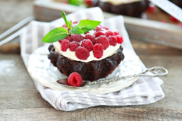 Süße Kuchen mit Himbeeren auf Holztischhintergrund