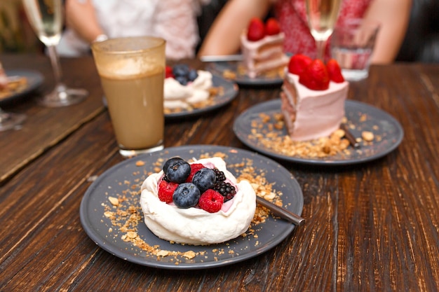 Süße Kuchen mit Sommerbeeren auf einem Holztisch. Party, süßer Tisch. Sommer bieten Desserts im Restaurant.