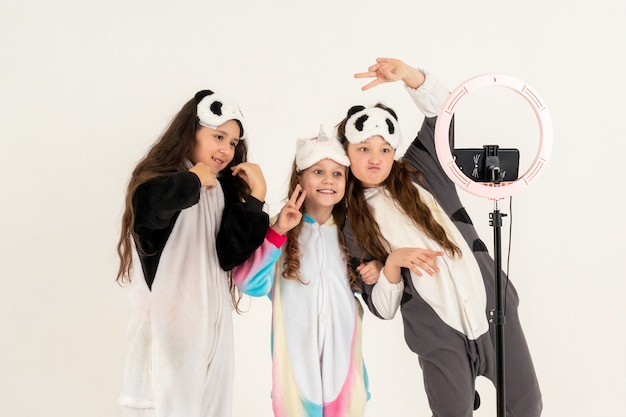 Süße Mädchen in Onesies und Schlafmasken