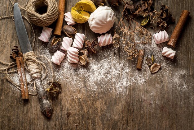 Süße Marshmallow-Stücke mit verschiedenen Zutaten auf Holzhintergrund. Ansicht von oben. Platz kopieren