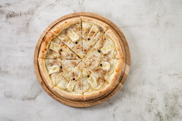 Süße Pizza mit Birnenkäse auf dem konkreten Hintergrund