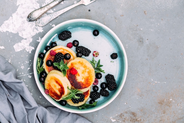 Süße Quarkpfannkuchen mit Himbeeren, Brombeeren und Johannisbeeren in einer Tellernahaufnahme