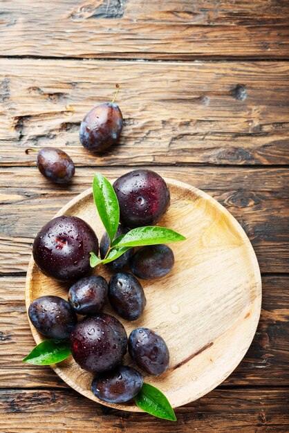 Süße rote Pflaumen auf Holztisch