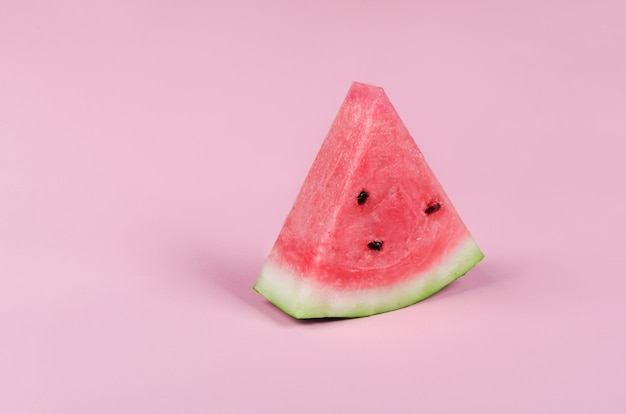 Süße saftige Wassermelonenscheibe auf rosa Hintergrund