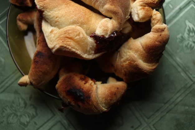 Süße Schokoladen-Croissants, selektiver Fokus auf alten Vintage-Hintergrund. Frische hausgemachte Croissants mit Schokolade. Croissant mit Schokoladenüberzug auf dem Teller.